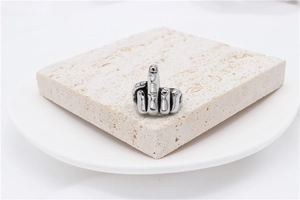Macro detail of vintage punk rock middle finger gesture ring on natural stone plate