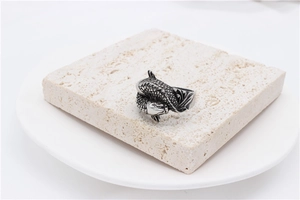 Macro shot of vintage koi carp twin fish ring on stone base showing fine scale details