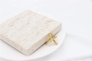 Macro view of gold Ankh cross ring on white travertine stone for Egyptian style