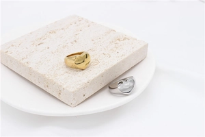 Detail view of heart-shaped metal rings in gold and silver finish on stone display