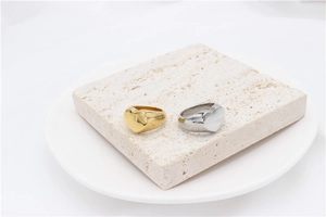 Macro shot of gold and silver minimalist heart rings with polished wide band finish