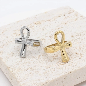 Gold and silver Ankh Egyptian steel rings displayed on a white textured stone base