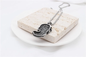 Détail du pendentif Méduse en acier titane vintage avec texture martelée et chaîne à billes