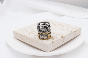 Macro detail of retro hollow crown and cross stainless steel rings on stone display