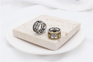 Detail shot of vintage hollow Roman crown rings with cross relief on stone tray