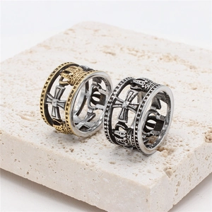 Vintage hollow crown steel rings with gothic cross patterns on stone pedestal