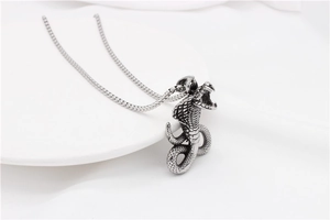 Macro detail of vintage silver cobra pendant with scales on a minimalist square chain