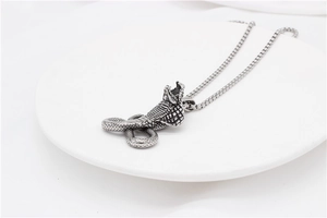 Detailed view of vintage cobra pendant with textured snake scales on steel box chain