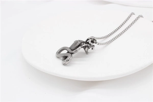Macro shot of cobra head pendant featuring detailed silver scales and open jaw design