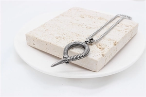 Close-up of vintage snake pendant with detailed scales on a minimalist ball chain