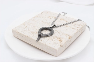 Close-up of vintage snake pendant showing detailed scales and textured metal craftsmanship