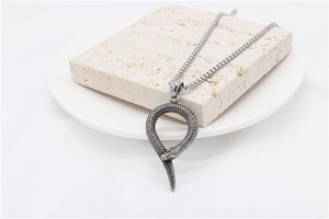 Detail of vintage snake pendant necklace with realistic scale texture on stone background
