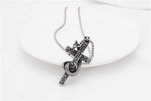 Dettaglio del pendente a croce in acciaio con serpente in stile vintage e catena a maglia