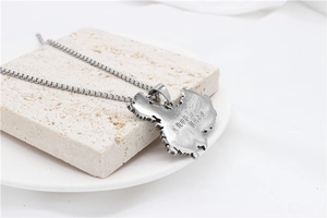 Detailed close-up of retro stainless steel China map pendant with engraved Chinese slogan