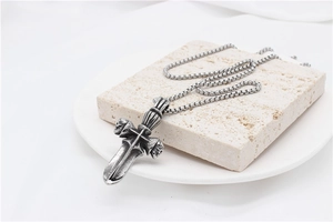 Detailed macro view of vintage gothic cross sword pendant with skull on box chain