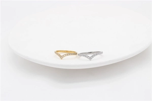 Dettaglio di anelli a corona minimalisti a forma di V in oro e argento con cristalli