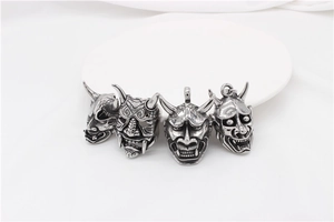 Detail view of retro Hannya ghost mask pendants with vintage blackened steel finish