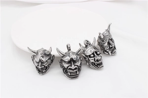 Macro shot of punk style stainless steel Hannya mask pendants with vintage finish