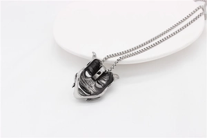 Detailed close-up of retro Prajna mask pendant on box chain with vintage finish