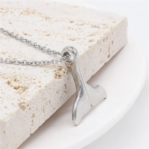 Collier pendentif queue de baleine en acier poli pour homme sur fond de pierre