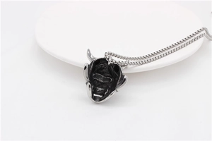 Macro shot of retro silver Hannya demon pendant with horn detail and stainless steel chain