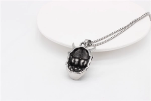 Macro shot of vintage Hannya mask pendant in distressed steel showing hollow back detail