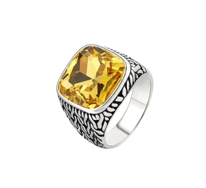 Vue de dessus d'une bague chevalière avec pierre jaune et anneau en métal gravé