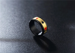Macro detail of rotating stainless steel poker ring with gold and black elements