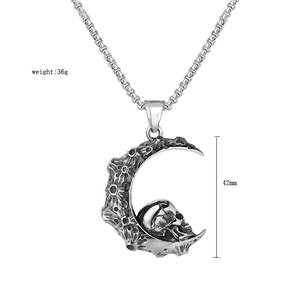 Macro detail of gothic crescent moon pendant with skull carving and vintage box chain