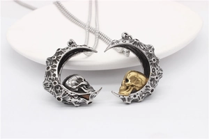 Macro detail of gothic moon and skull pendant in antique silver and gold stainless steel