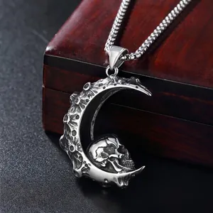 Gothic crescent moon and skull necklace in antique steel finish on a dark wood box