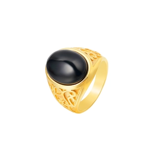 Macro shot of vintage gold steel ring featuring a black cat eye stone and ornate engravings