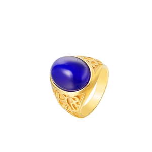 Detail of vintage gold steel ring featuring a blue oval gem and intricate openwork carving