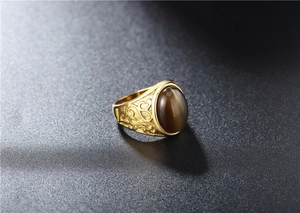 Detailed macro view of vintage gold titanium ring featuring brown cat eye stone and filigree