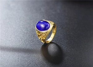 Close-up of gold titanium ring with dark blue cat eye stone and hollow carvings