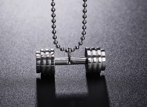 Vue macro d'un pendentif haltère argenté avec chaîne à boules pour fan de fitness