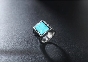 Dettaglio dell'anello retrò in acciaio inossidabile con turchese blu e motivi geometrici