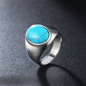 Vintage titanium steel ring with oval turquoise stone on a grey minimalist background
