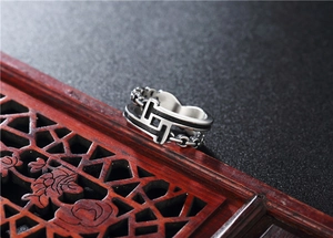 Macro detail of retro titanium steel chain ring on decorative red vintage wooden stand