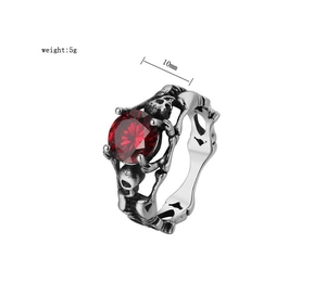Detailed macro view of gothic skull ring with large red zircon gemstone and steel carvings