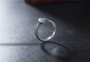 Dettaglio macro di anello a serpente argento vintage con trama a scaglie e stile gotico