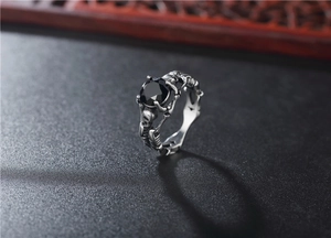 Macro shot of gothic skull ring with large black gemstone and vintage steel finish
