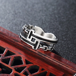 Retro titanium steel chain ring featuring geometric patterns on a vintage wooden prop