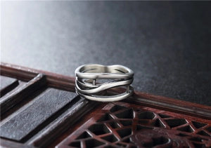 Macro detail of vintage silver-plated ring with layered wavy lines and hollow structure