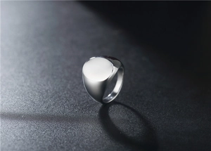 Detalle macro de un anillo de sello plateado pulido para hombre con superficie plana