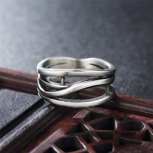 Irregular multilayer intertwined silver ring with vintage oxidation finish on wood tray