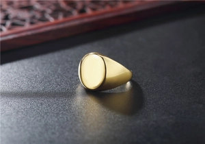Primer plano de anillo de sello ovalado dorado en acero inoxidable pulido de calidad
