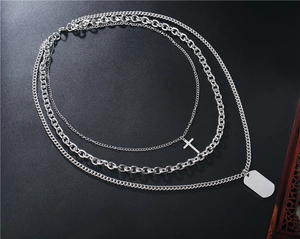 Détail d'un collier triple couche en acier titane argenté avec croix et plaque militaire