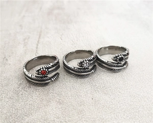 Detailed view of three vintage feather rings with inlaid red, white, and black gemstones