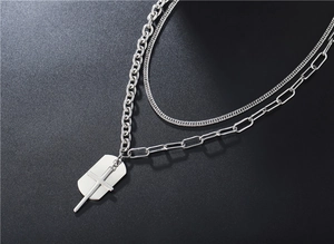 Dettaglio della collana punk argento con catene a più strati e ciondolo a croce